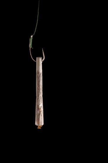 Marijuana cigarette hanging from a hook drug addiction concept close-up isolated on black background