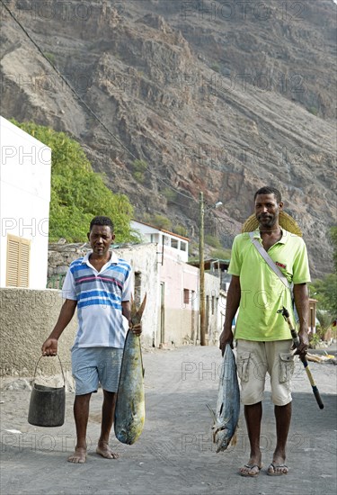 Locals carry fish across a street