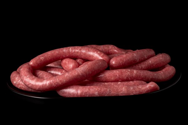 Homemade meat sausages with pepper shaker isolated on black background and copy space