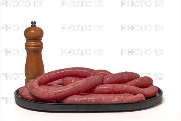 Homemade meat sausages with pepper shaker isolated on white background and copy space