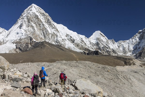 Trekkers crossing the glacier moraines en-route of the Everest Base Camp trek