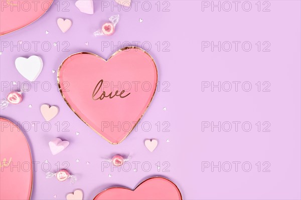 Pastel colored Valentine's Day flat lay with heart shaped plates