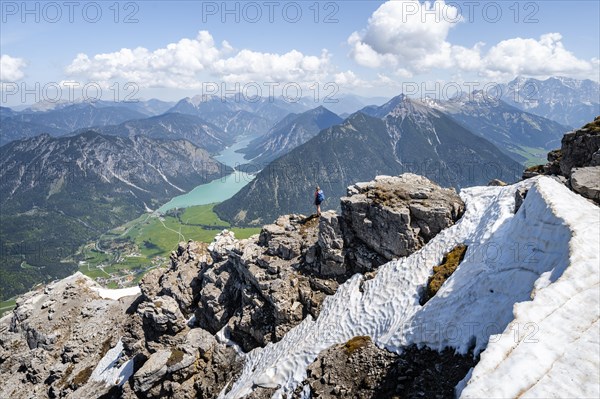 Hiker looking down from Thaneller to Plansee and eastern Lechtal Alps