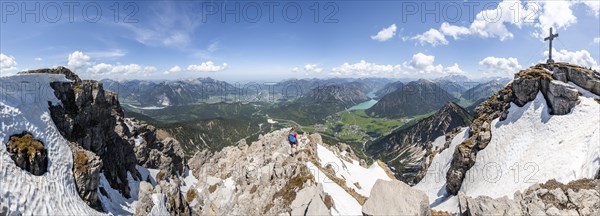 Hiker looking down from Thaneller to Plansee and eastern Lechtal Alps