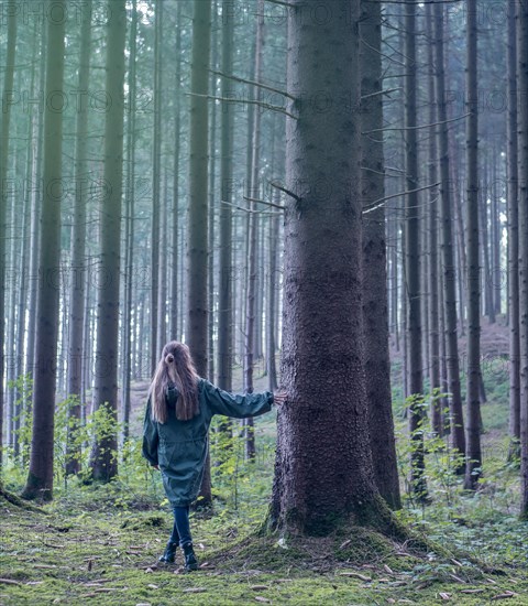 Young woman girl lady in the forest near the tree leaning