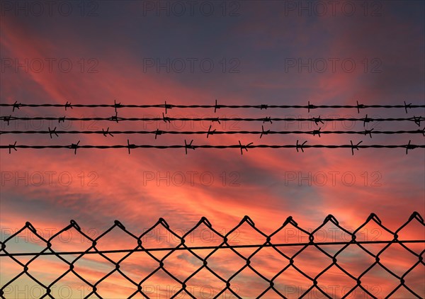 Chain link fence with additional barbed wire