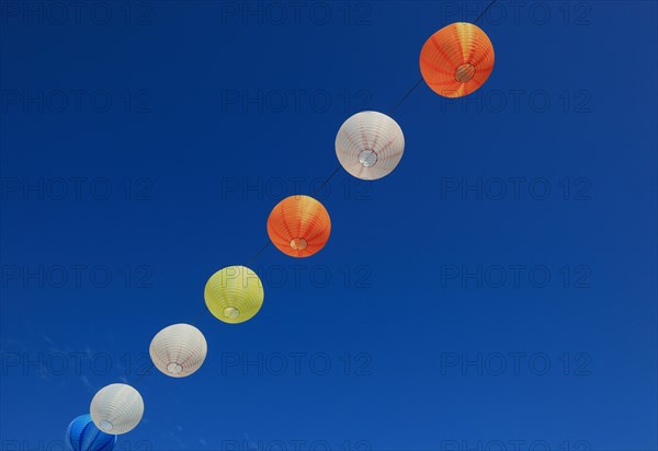 Colourful lanterns hanging on a line over the street