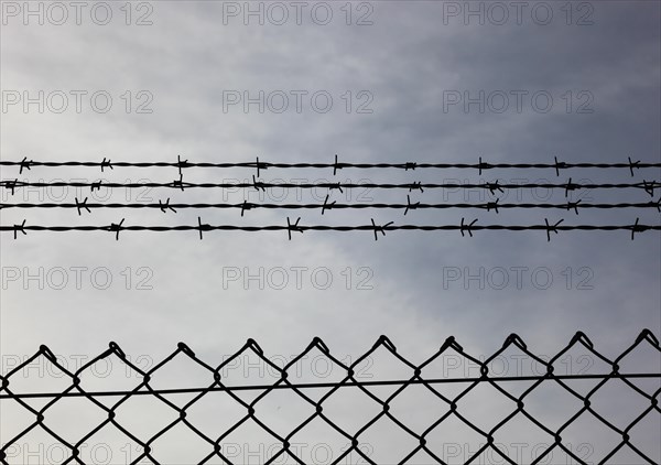 Chain link fence with additional barbed wire