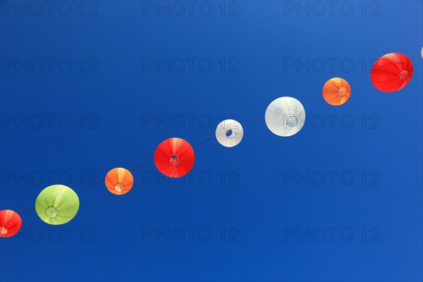 Colourful lanterns hanging on a line over the street