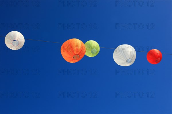 Colourful lanterns hanging on a line over the street