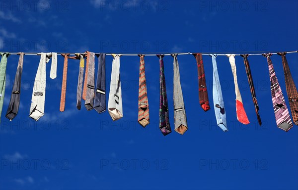 Many colourful ties hanging on a clothesline