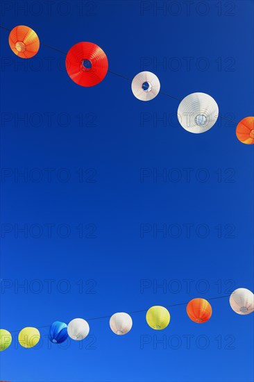 Colourful lanterns hanging on a line over the street