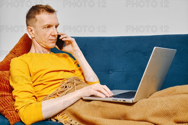 Middle-aged man consults with his accountant while filling tax form online