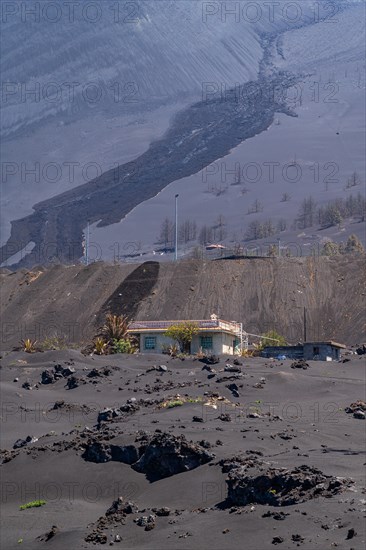 Damaged house in front of the new volcano at the Canos de Fuego visitor centre