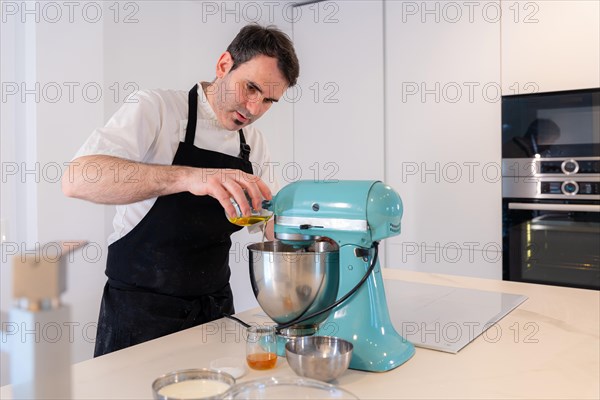 A man baker bakes a red velvet cake at home