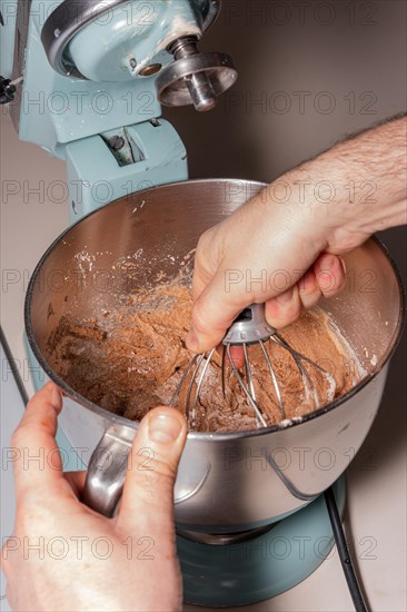 Hands of a man cooking a red velvet cake at home