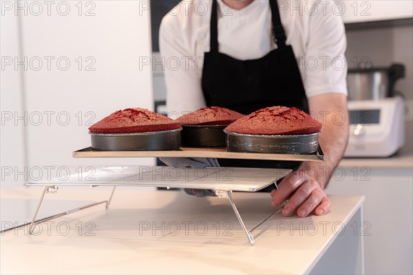 Hands of a man bakes a red velvet cake at home