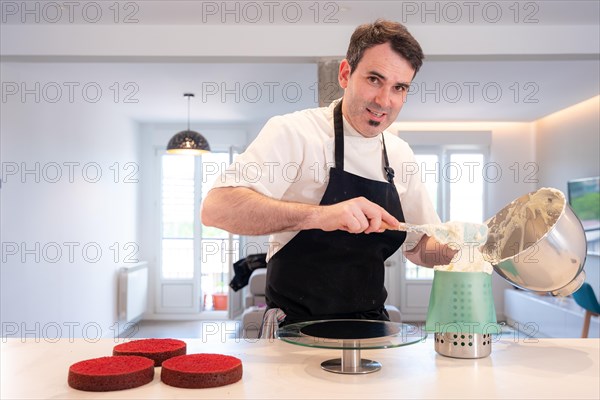 Hands of a man bakes a red velvet cake at home