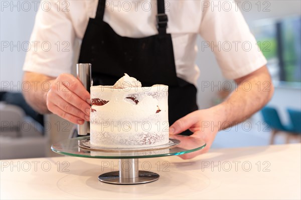 Hands of a man bakes a red velvet cake at home