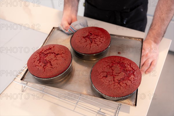 Hands of a man bakes a red velvet cake at home