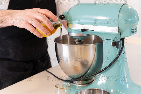 A man baker bakes a red velvet cake at home