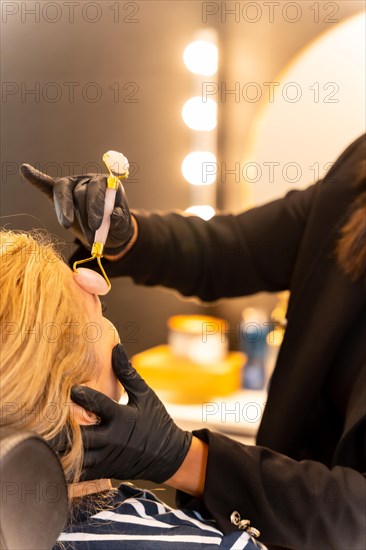 Latin ethnic woman in a beauty shop working with the client's eyebrows