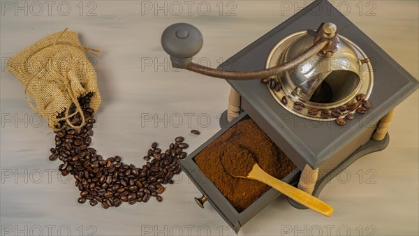 Coffee beans and ground coffee with coffee grinder and flowers