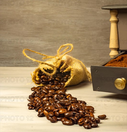 Coffee beans and ground coffee with coffee grinder and flowers