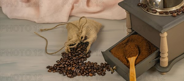 Coffee beans and ground coffee with coffee grinder and flowers