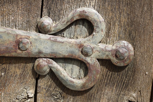 Old iron door fitting on an old brown wooden door