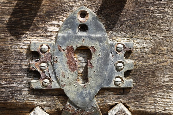 Old iron door lock on an old brown wooden door