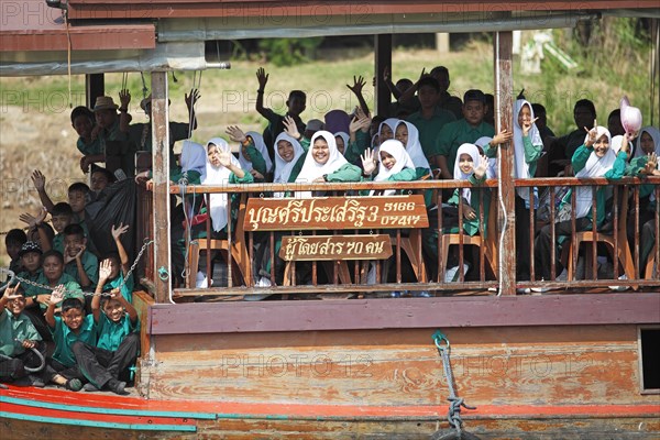Schoolgirl in school uniform on a rice barge on the Chao Phraya