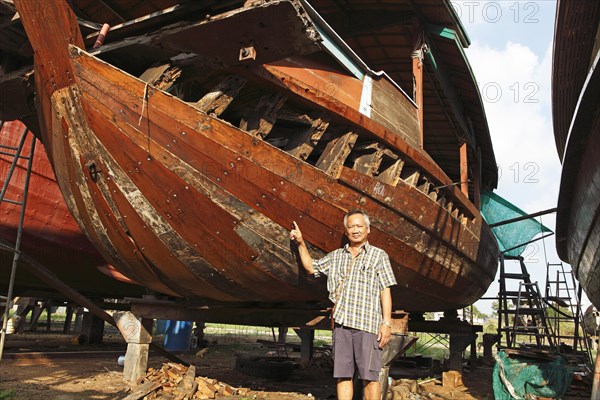 Thai boat builder showing one of his rice barges