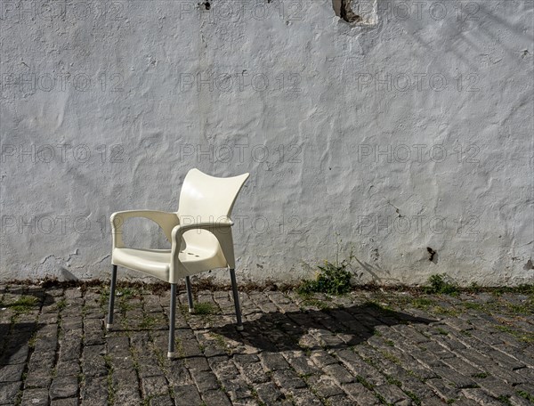 White plastic chair in front of old house facade