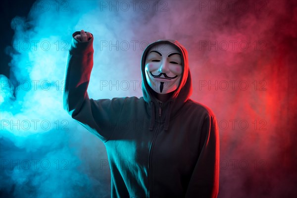 Hacker with anonymous mask with his fist raised in symbol of fight