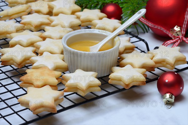 Christmas biscuits on cake rack and tray with lemon curd