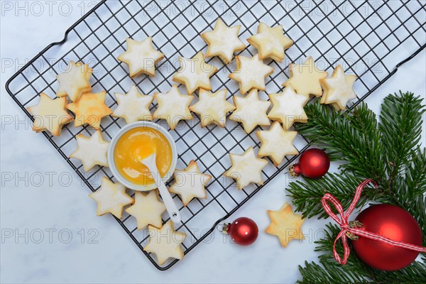 Christmas biscuits on cake rack and tray with lemon curd