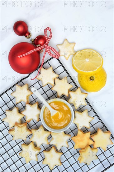 Christmas biscuits on cake rack and tray with lemon curd