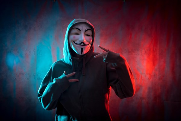 Hacker with anonymous mask making the victory symbol