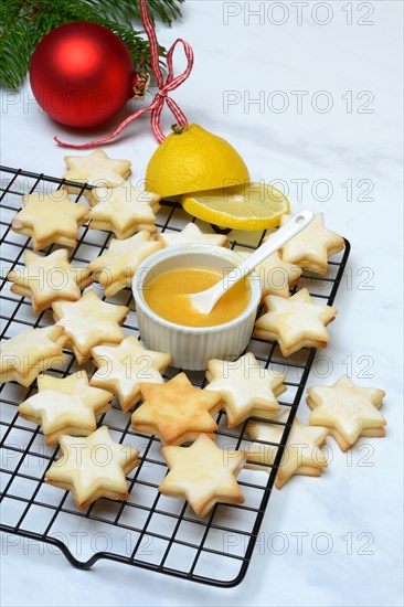 Christmas biscuits on cake rack and tray with lemon curd