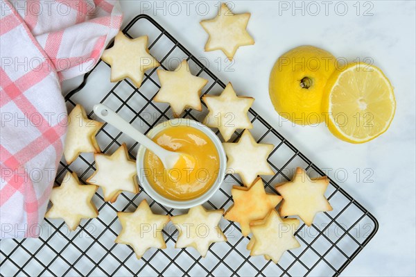 Christmas biscuits on cake rack and tray with lemon curd