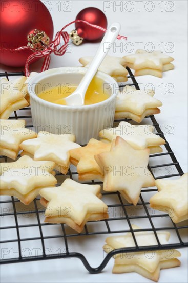 Christmas biscuits on cake rack and tray with lemon curd