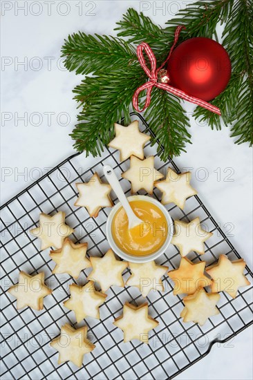 Christmas biscuits on cake rack and tray with lemon curd