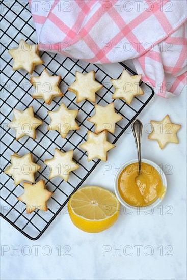 Christmas biscuits on cake rack and tray with lemon curd