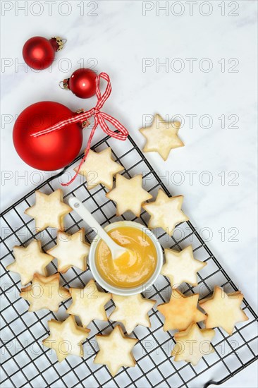 Christmas biscuits on cake rack and tray with lemon curd