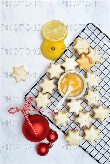 Christmas biscuits on cake rack and tray with lemon curd