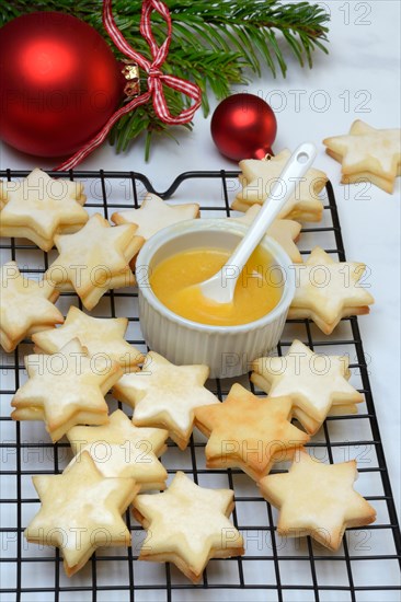 Christmas biscuits on cake rack and tray with lemon curd