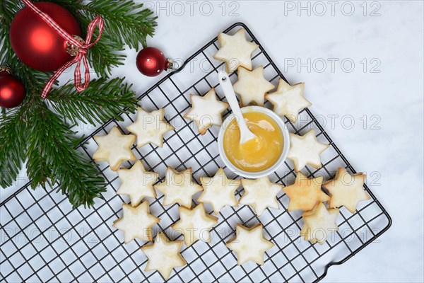 Christmas biscuits on cake rack and tray with lemon curd