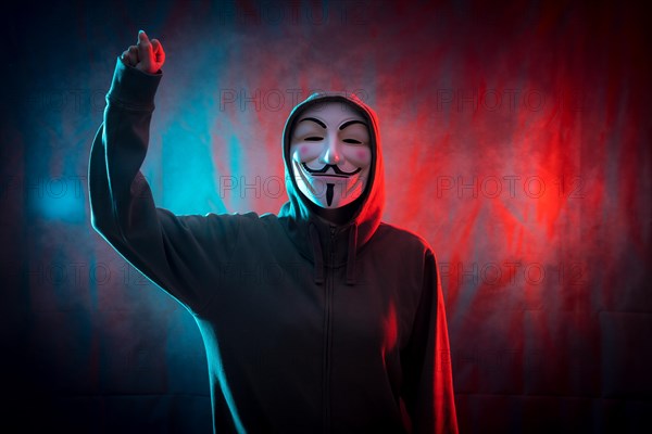 Hacker with anonymous mask with his fist raised in symbol of fight