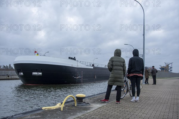 Onlookers look at a newly built tanker